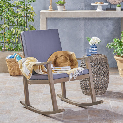Arend Coastal Acacia Wood Outdoor Rocking Chair with Cushions and Cross-Back Detailing by Gracie Oaks