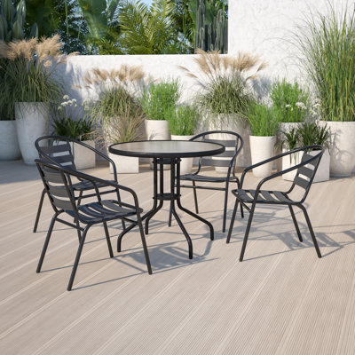Amlie 31.5" Round Glass Metal Table with 4 Metal Aluminum Slat Stack Chairs by Wade Logan